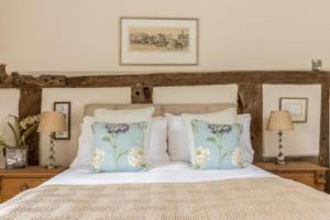 a bedroom with a bed with pillows and two lamps at Pinley Hill House in Warwick