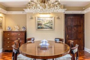 a dining room with a wooden table and a chandelier at Pinley Hill House in Warwick
