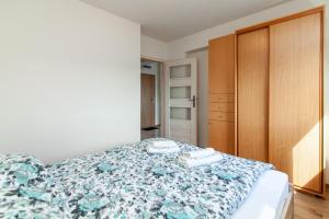 sypialnia z łóżkiem z niebieską narzutą kwiatową w obiekcie Apartament Rodzinny w mieście Białystok