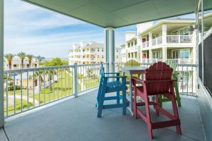two chairs and a table on the balcony of a condo at Beach Retreat in Galveston