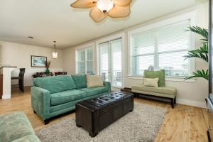 a living room with a green couch and a fan at Beach Retreat in Galveston