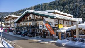 ein großes Gebäude mit Schnee auf einem Berg in der Unterkunft Hotel Mitterhof in Gerlos