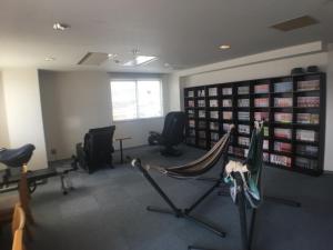 a gym with chairs and a hammock in a room at Hotel Shibukawa Hills in Shibukawa