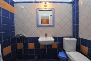 a bathroom with a sink and a toilet and a mirror at St.George Valsamitis in Katapola