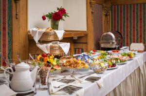 a long table with food and plates of food at Pałac Spiż koło Karpacza in Karpacz