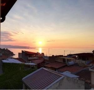 un coucher de soleil sur une ville avec des bâtiments et l'océan dans l'établissement Antico Vicolo, à Scilla