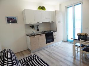 a kitchen with white cabinets and a sink and a table at Appartamento due sorelle in Sirolo