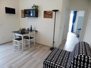 ein Wohnzimmer mit einem Tisch, einem Tisch und Stühlen in der Unterkunft Appartamento due sorelle in Sirolo