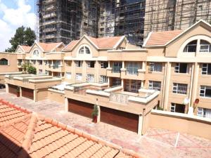 a large tan building with a lot of windows at Embassy Gardens 17 West Rd South Morningside Sandton Johannesburg Secure 2 Bedroom fully furnished apartment with 24hrs security in Johannesburg