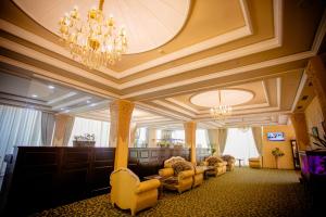 a living room with chairs and a chandelier at Gloria Hotel in Tashkent