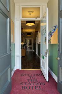 a hallway with a door leading to a room with a rug at Station Hotel in Thurso