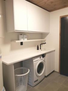 a kitchen with a washing machine under a counter at Lyngen Vista - Arctic Boutique Lodge in Hamnnes +95 photos