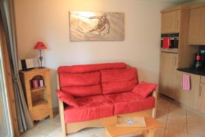 ein Wohnzimmer mit einem roten Sofa und einem Tisch in der Unterkunft At Home in Les Carroz d'Araches