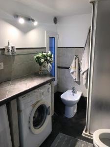 ein Badezimmer mit einer Waschmaschine und einem Waschbecken in der Unterkunft Casa Celeste Fregene, il mare di Roma in Fregene