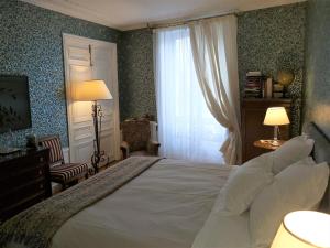 a bedroom with a large white bed and a window at Le 48 Paris in Paris