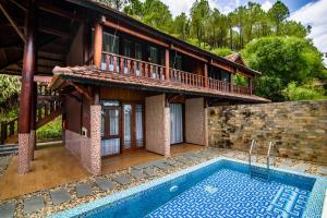 une maison avec une piscine à côté d'un bâtiment dans l'établissement Sankofa Village Hill Resort & Spa, à Hue