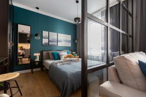 a bedroom with a bed and a blue wall at Apartamenty Flat White Obywatelska 47AB in Zielona Góra