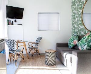 a living room with a couch and chairs and a table at Palm Cottage in Durban