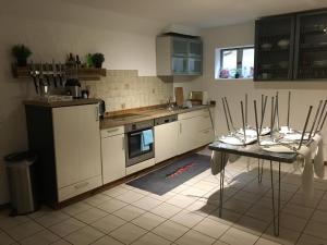 a kitchen with white appliances and a table with chairs at Ferienwohnung-Birlenbach in Birlenbach
