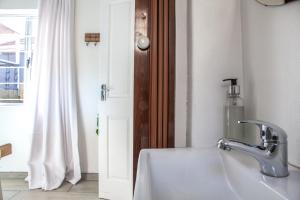 a bathroom with a sink and a window at Palm Cottage in Durban +29 photos