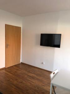 Zimmer mit einer Tür und einem TV an der Wand in der Unterkunft Apartament Matejki 7/4 in Zielona Góra