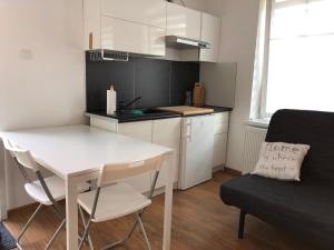 małą kuchnię z białym stołem i krzesłem w obiekcie Apartament Matejki 7/4 w Zielonej Górze