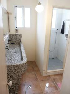 y baño con lavabo y ducha. en Backpacker 41 Hostel - Kaohsiung, en Kaohsiung