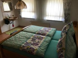 ein Schlafzimmer mit einem Bett mit einer Decke darauf in der Unterkunft Ferienwohnung Wand in Bad Lauterberg