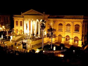 ein großes Gebäude mit Lichtern in der Nacht davor in der Unterkunft Palco Noir! in Palermo