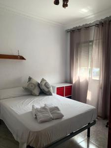 マラガにあるCalle cómico Riquelme 23 segundoのベッドルーム1室(白いベッド1台、タオル付)