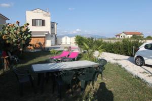 a table and chairs in a yard with a car at "La Rondinella" Salerno Amalfi Pontecagnano in Pontecagnano