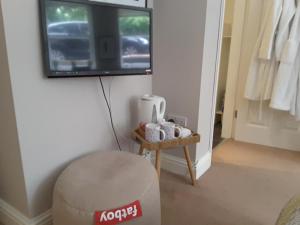 a room with a ottoman and a television on a wall at Fabulous Double ensuite room in Sefton Park Lark Lane in Liverpool