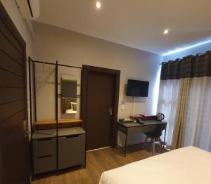 a hotel room with a bed and a desk and a mirror at La Orchard Hotel in Johannesburg