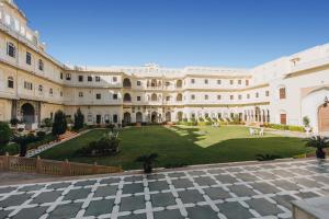 齋浦爾的住宿－拉傑宮酒店（世界小型奢華酒店），享有带草坪的建筑庭院的景色