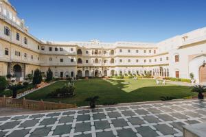 Blick auf den Innenhof eines Gebäudes mit Rasen in der Unterkunft The Raj Palace (Small Luxury Hotels of the World) in Jaipur