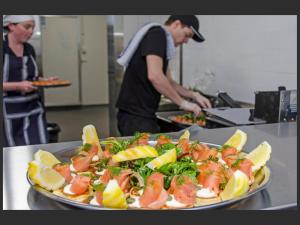 a man preparing food in a kitchen with a plate of food at The Parade Hotel in Bunbury
