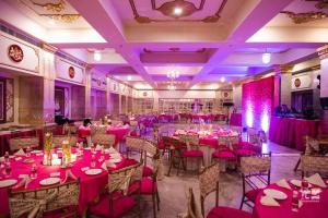 una sala banchetti con tavoli e sedie rosa di The Raj Palace (Small Luxury Hotels of the World) a Jaipur Altre 37 foto