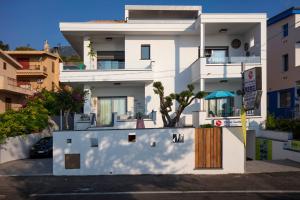 a white apartment building with a wooden door at Appartamenti Jlune in Cala Gonone