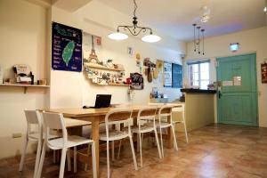a kitchen with a table and chairs with a laptop on it at Backpacker 41 Hostel - Kaohsiung in Kaohsiung
