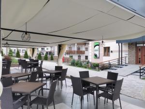 an outdoor patio with tables and chairs and a building at Zlatibor Hills 31 in Zlatibor