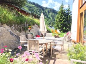 a table and chairs with an umbrella on a patio at Haus 7 Stuben in Stuben am Arlberg