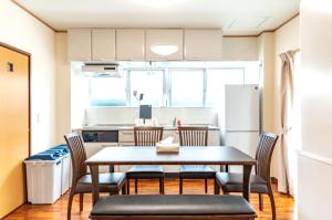 a kitchen and dining room with a table and chairs at 隠れ宿ＴＯＭＡＲo in Motobu