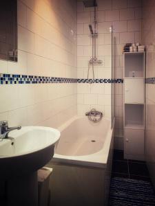 een badkamer met een bad en een wastafel bij Paul's Place near Heathrow in Londen