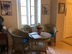 d'un salon avec une table, des chaises et une fenêtre. dans l'établissement Las Canéres, à Castelnau-dʼArbieu