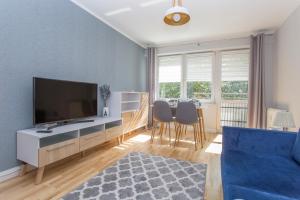 uma sala de estar com televisão e uma mesa com cadeiras em CR Rodzinny Apartament Chrobrego 16 em Bialystok