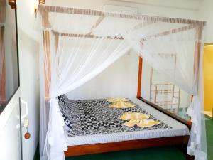 a bed with a canopy in a room at Nature Home in Mirissa