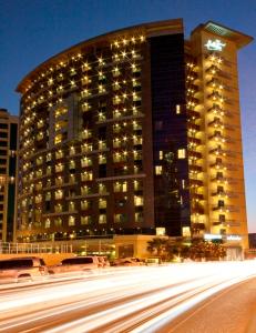 a large building with lights on the side of it at Grand Bellevue Hotel Apartment Dubai in Dubai