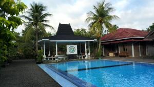 una piscina di fronte a una casa con gazebo di Lucia Cottages a Sukarame