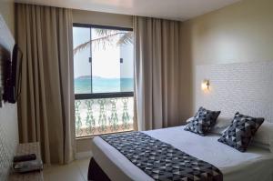 a bedroom with a bed and a large window at Flat Pietra in Florianópolis