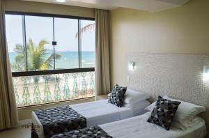 a hotel room with two beds and a large window at Flat Pietra in Florianópolis +37 photos